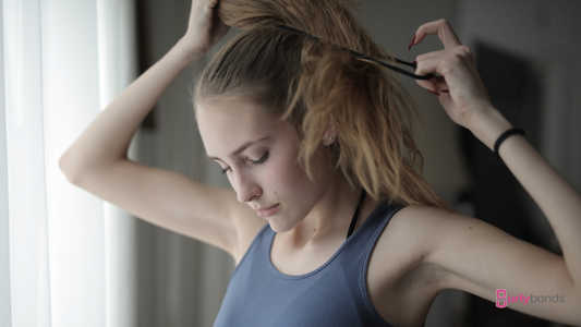 woman putting hair up in hair tie