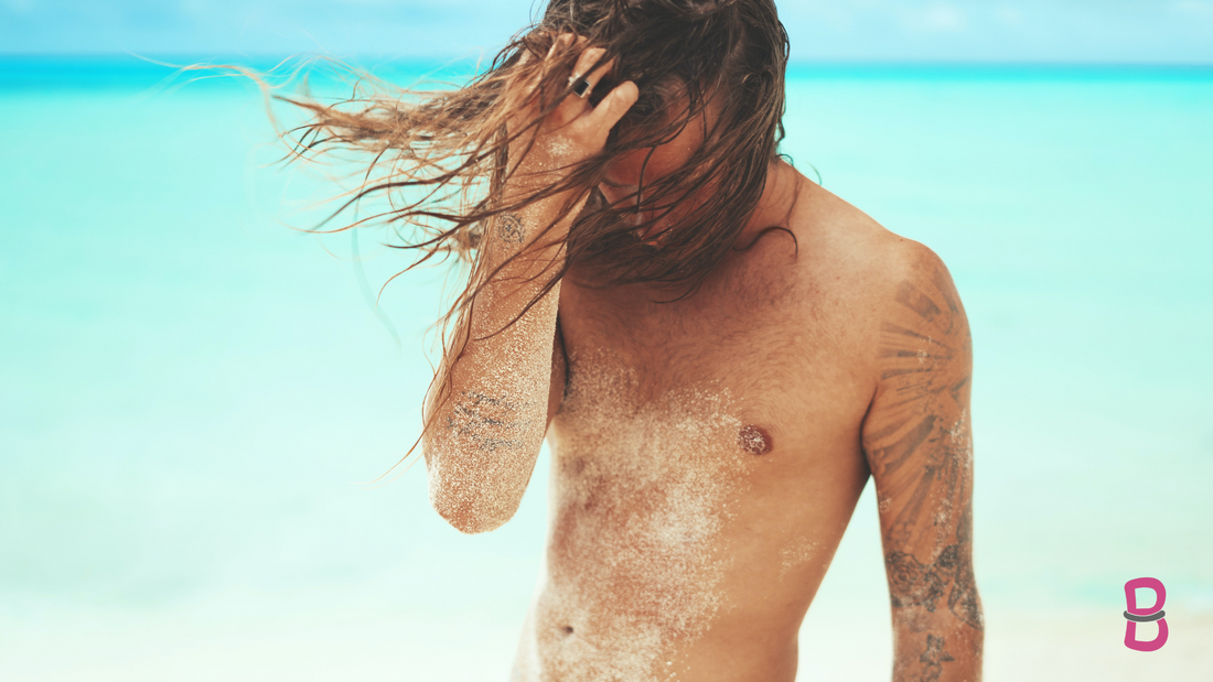 man with long hair on beach